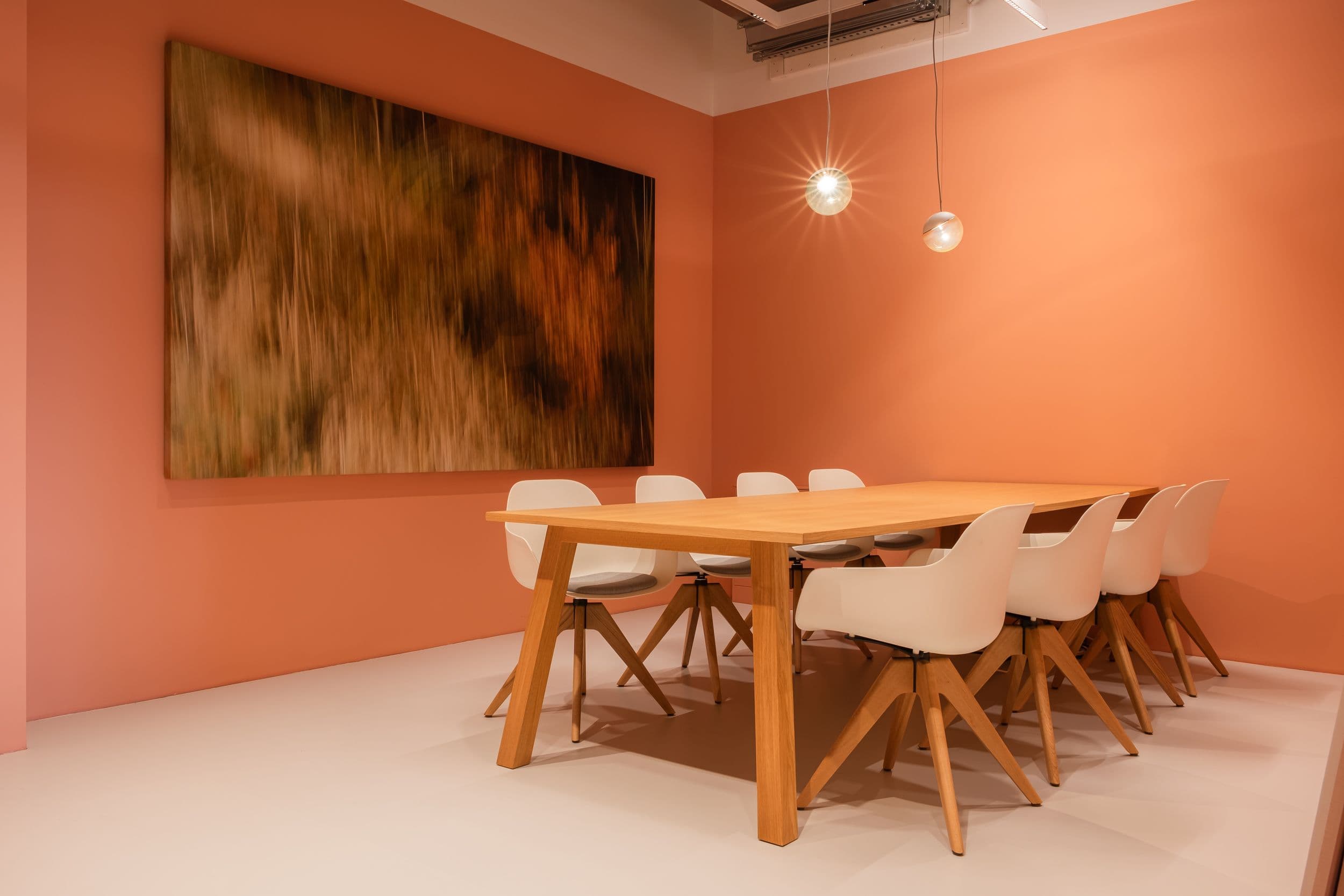 Farbige Besprechungsräume der Formo Zentrale Berlin mit gelber und terrakottafarbener Wandgestaltung, Eichentischen, weißen Schalenstühlen und Glastrennwänden mit Beschriftung, Innenarchitektur Susanne Philippson
