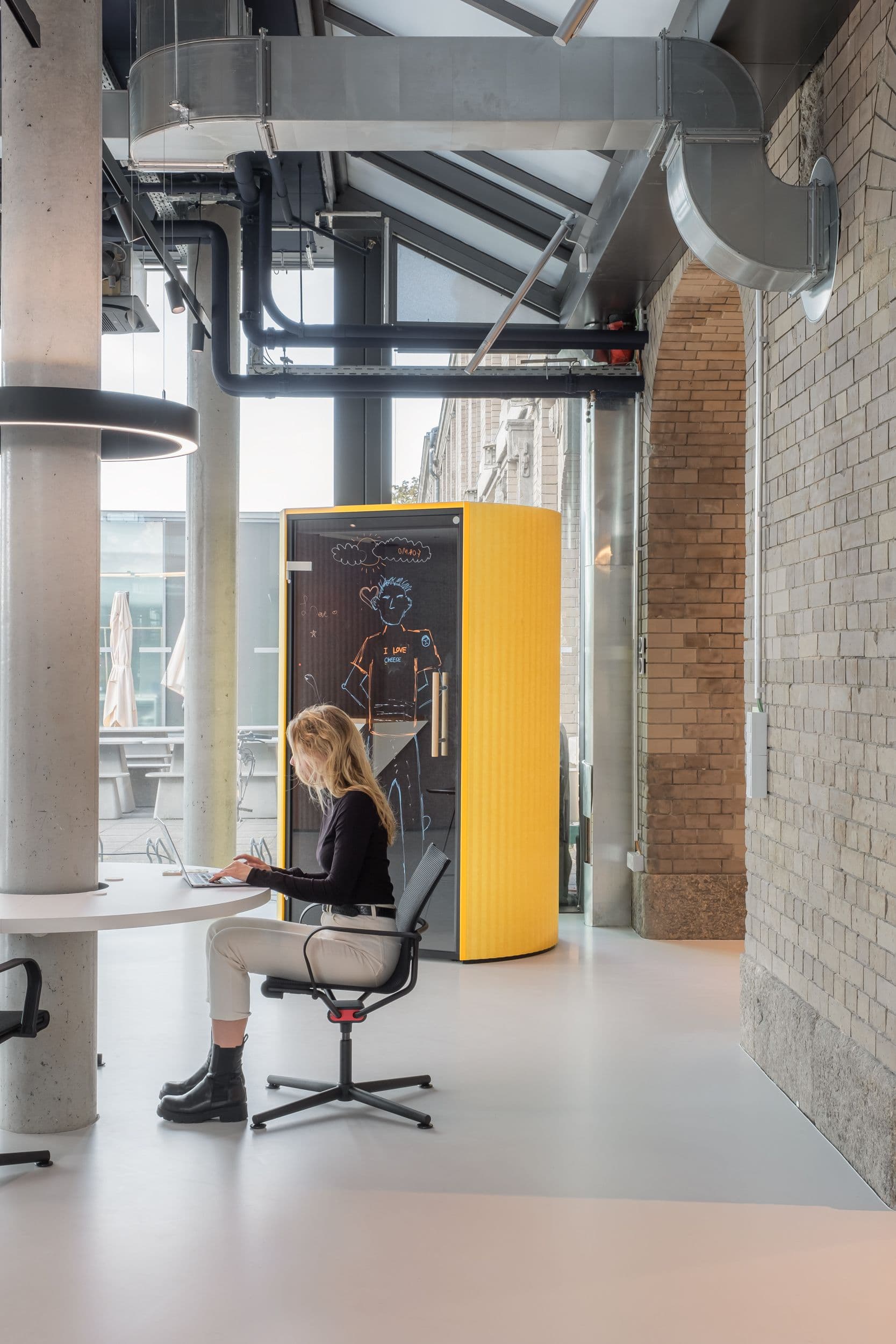 Offener Arbeitsbereich der Formo Zentrale Berlin mit Backsteinbögen, höhenverstellbaren Schreibtischen, quadratischen Akustik-Lichtdecken und Blick auf den zentralen Kollaborationsbereich, Innenarchitektur Susanne Philippson