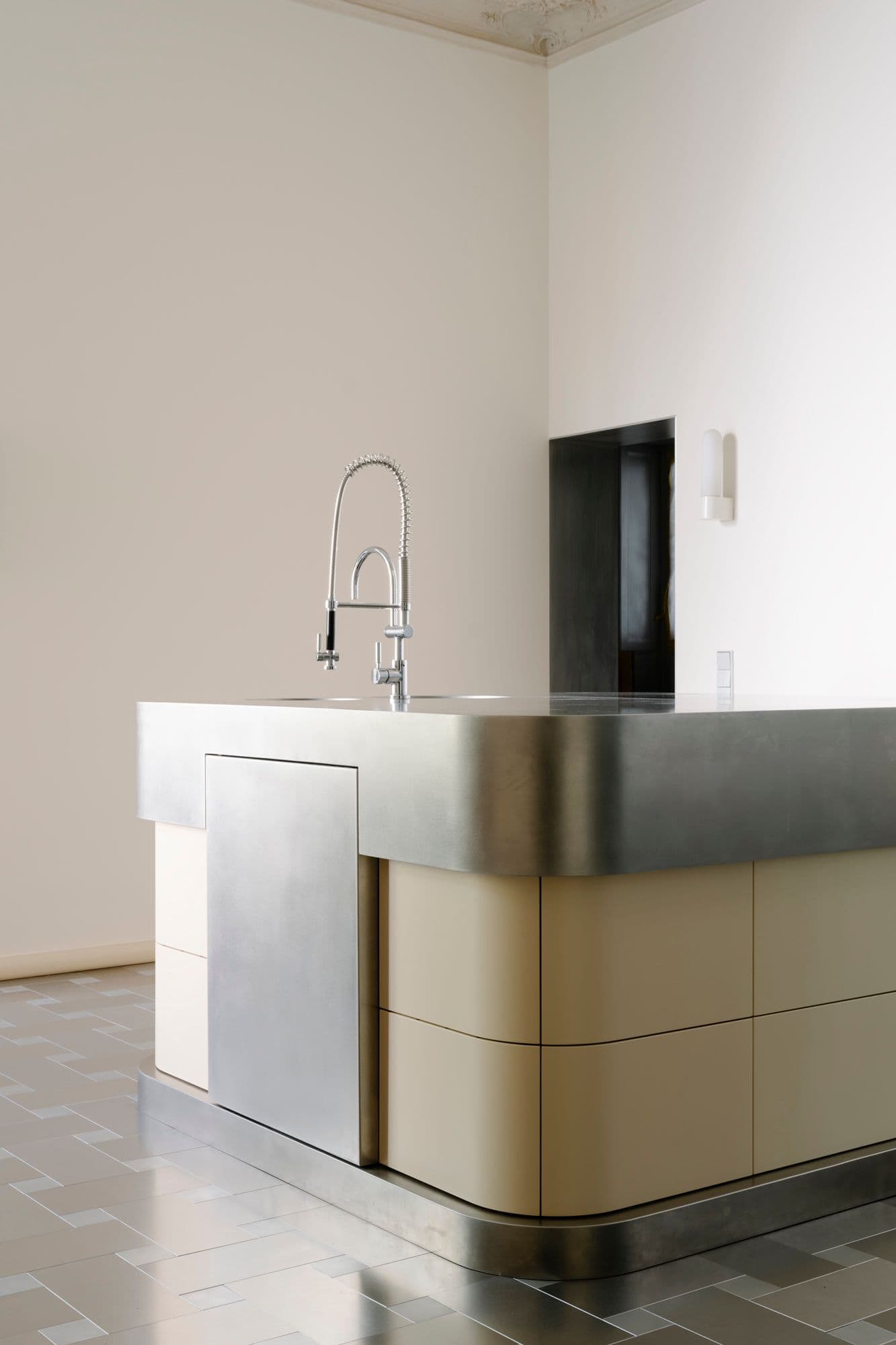 Maßgefertigte Edelstahlkücheninsel einer Berliner Altbauwohnung mit geöffneter Schublade mit Holzeinsatz, zweifarbigem Fliesenboden im Schachbrettmuster und geschlossener sowie geöffneter Spülmaschine, Innenarchitektur Susanne Philippson