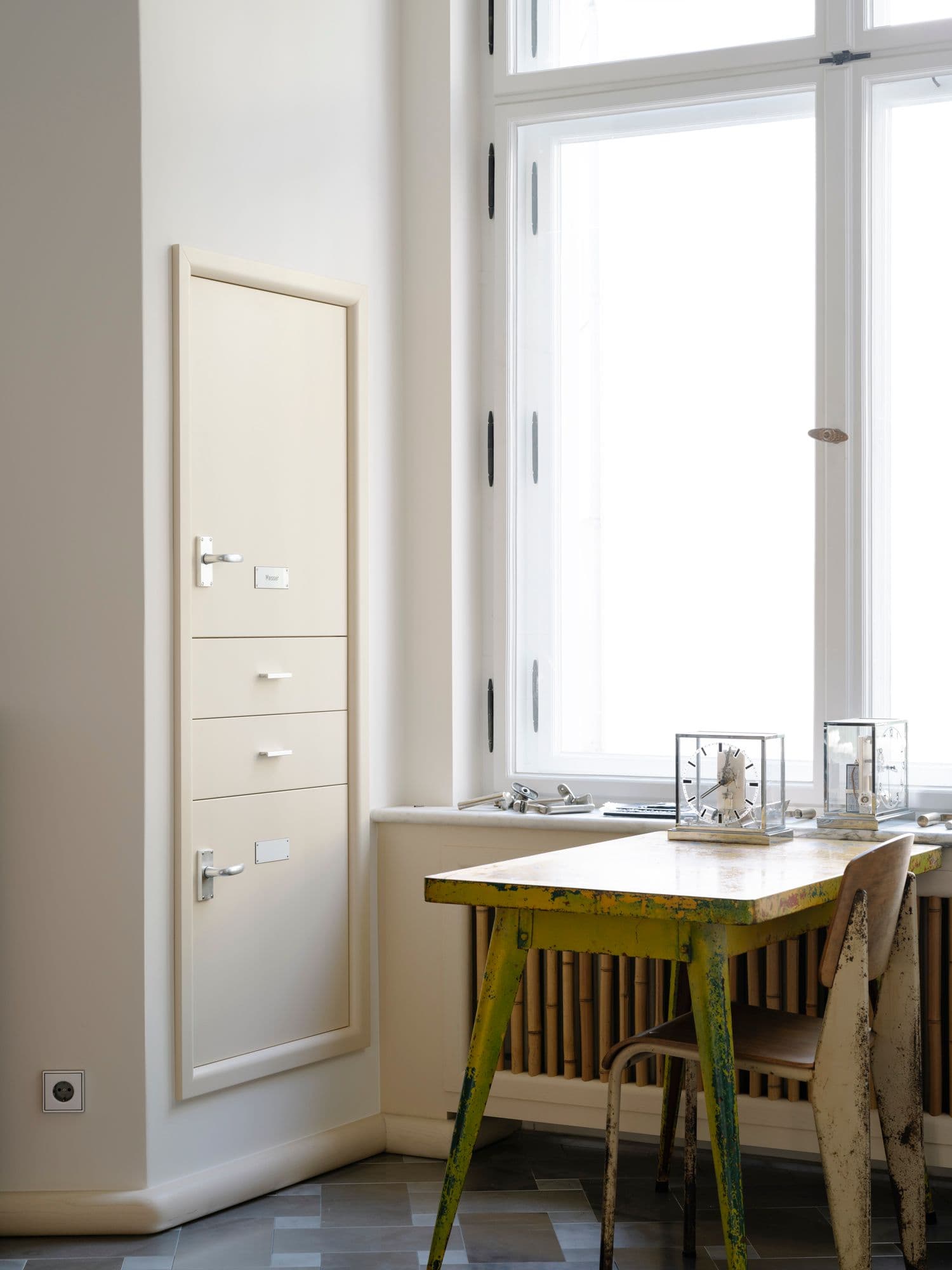 Maßgefertigter Einbauschrank in einer Berliner Altbauwohnung mit geöffnetem Holzeinsatz für Messeraufbewahrung, Schubladen und zweifarbigem Fliesenboden im Schachbrettmuster, Innenarchitektur Susanne Philippson