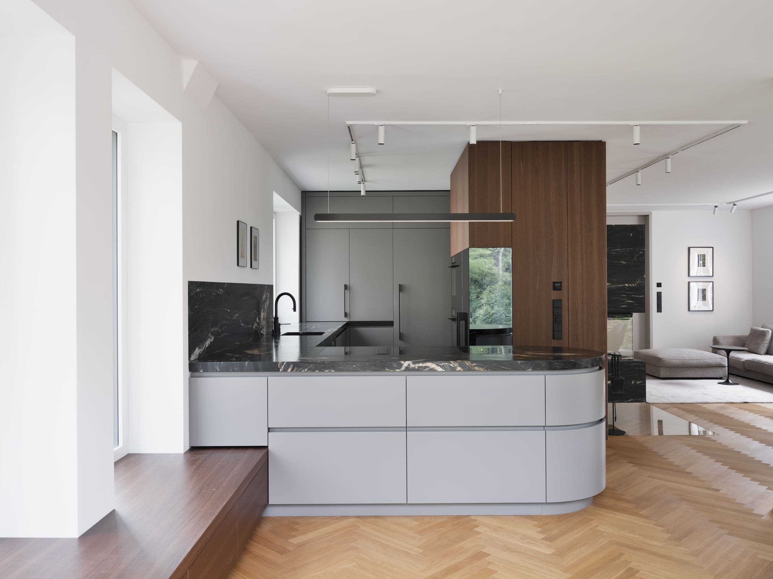 Maßgefertigte Küche mit schwarzem Marmor, gerundeter Kücheninsel und Holzeinbauten in einer Berliner Wohnungssanierung, Innenarchitektur Susanne Philippson