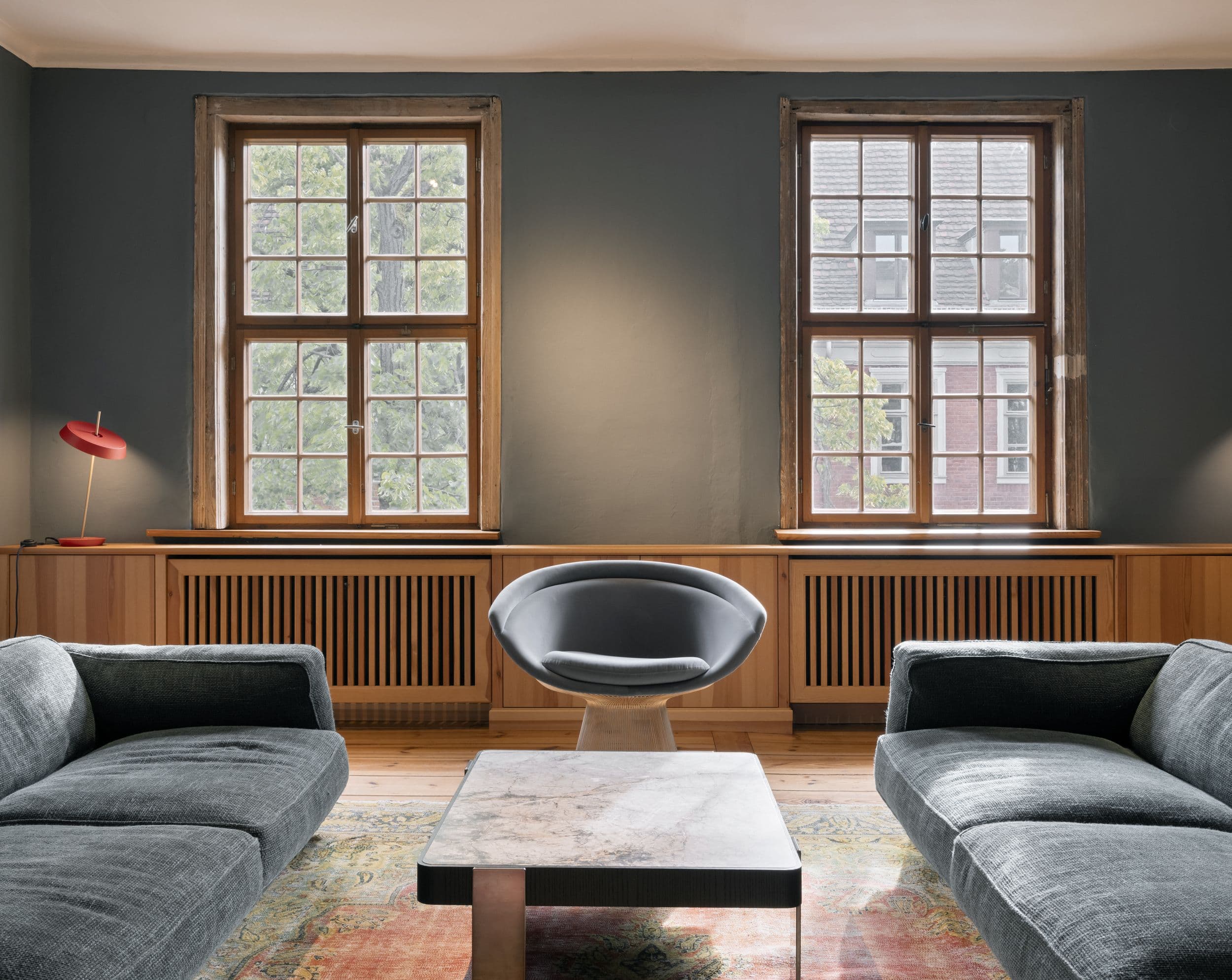 Wohnzimmer der B21 im holländischen Viertel Potsdam mit offenem Kamin, grauem Ecksofa, großformatigem Kunstwerk und historischen Kieferndielen, Innenarchitektur Susanne Philippson