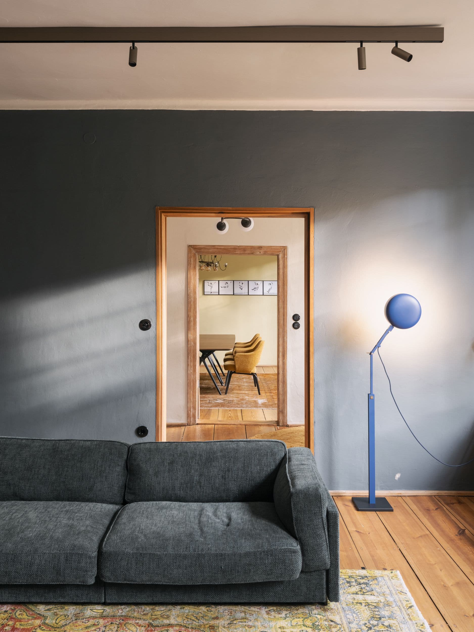 Wohnzimmer der B21 im holländischen Viertel Potsdam mit offenem Kamin, grauem Ecksofa, großformatigem Kunstwerk und historischen Kieferndielen, Innenarchitektur Susanne Philippson
