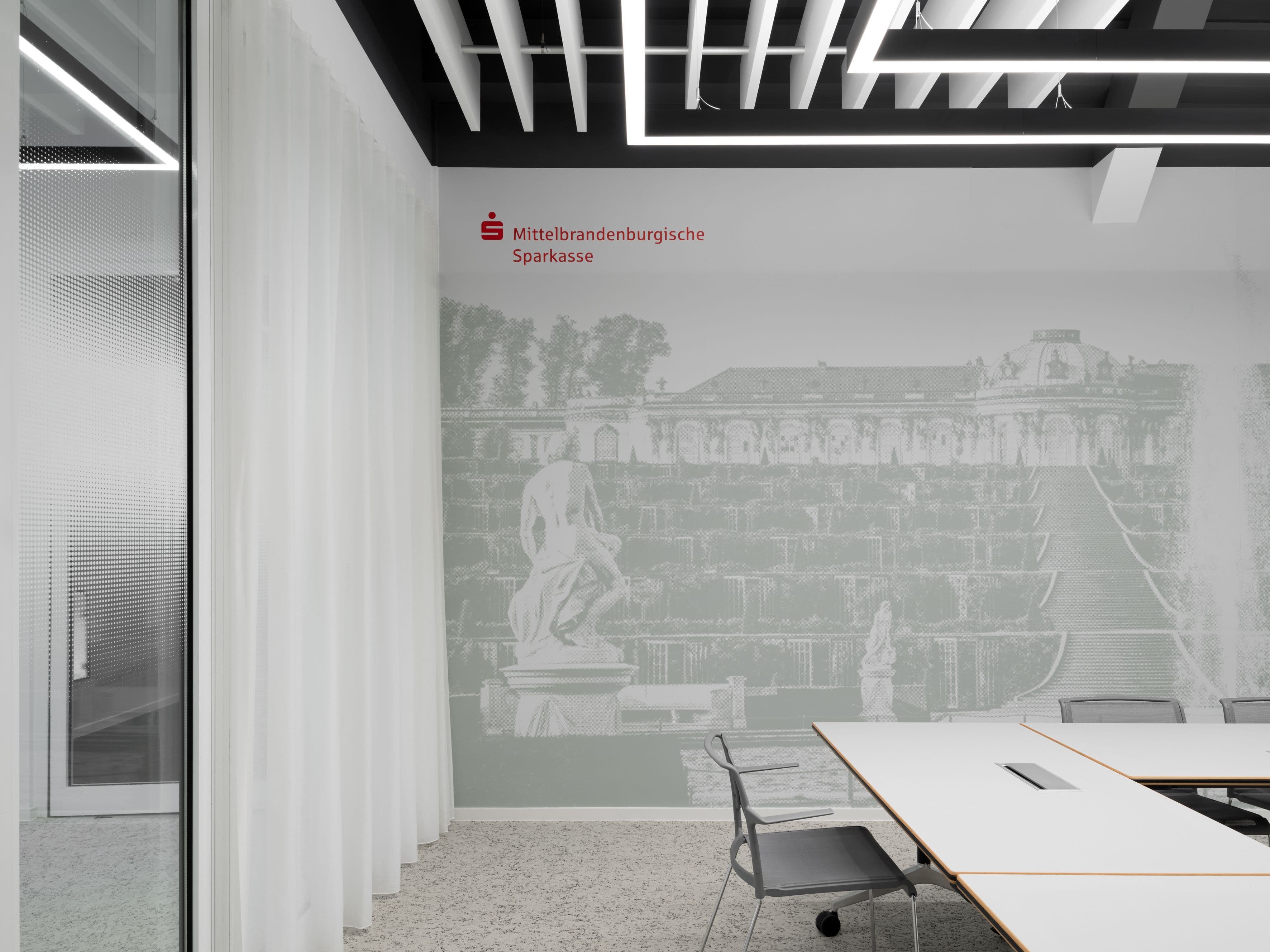 Schulungsraum mit abstrahiertem Sanssouci-Wandmotiv, linearem Lichtkonzept und Wilkhahn-Stuhl im MBS-Schulungszentrum am Luisenplatz Potsdam