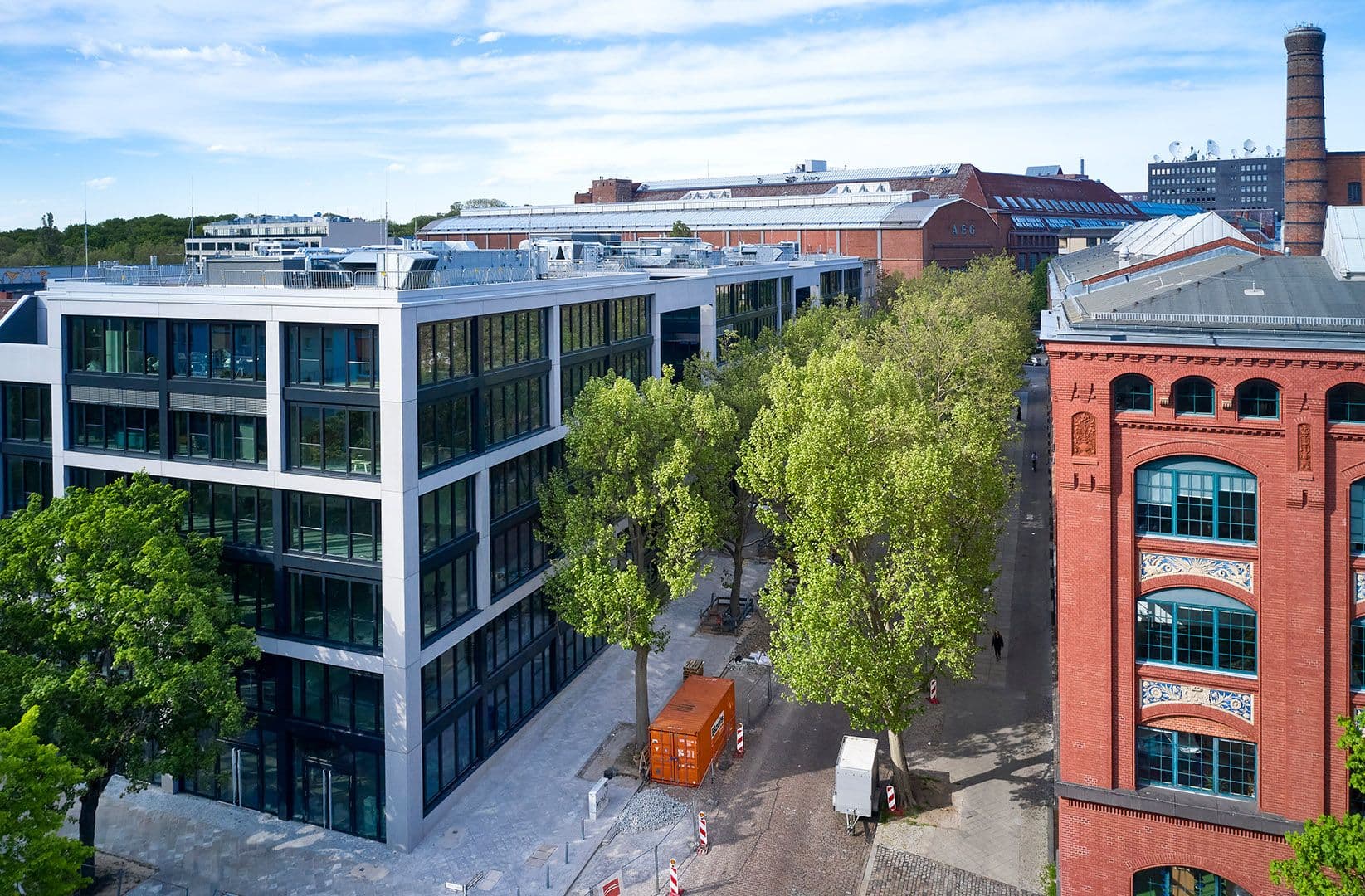 Außenansicht des Merantix Campus Berlin mit modernem Neubau und historischen AEG-Backsteingebäuden im Hintergrund