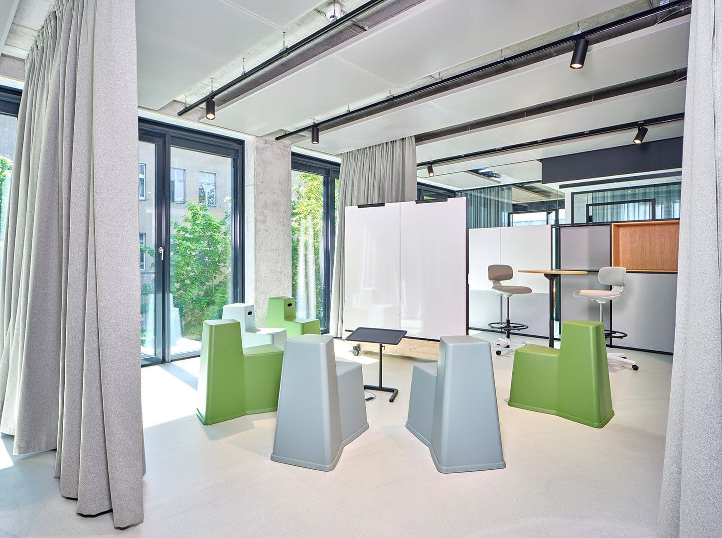 Flexibler Workshop-Bereich mit modularen Sitzelementen, Vorhangtrennwänden und Whiteboard im Merantix Campus Berlin