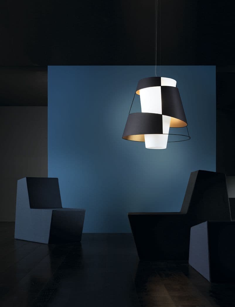 Crinolina Pendelleuchte von Pallucco in Anthrazit mit asymmetrisch strukturiertem Stoffdiffusor und goldfarbenem Lichtreflex in dunklem Raumambiente mit skulpturalen Sesseln, Leuchtendesign Susanne Philippson