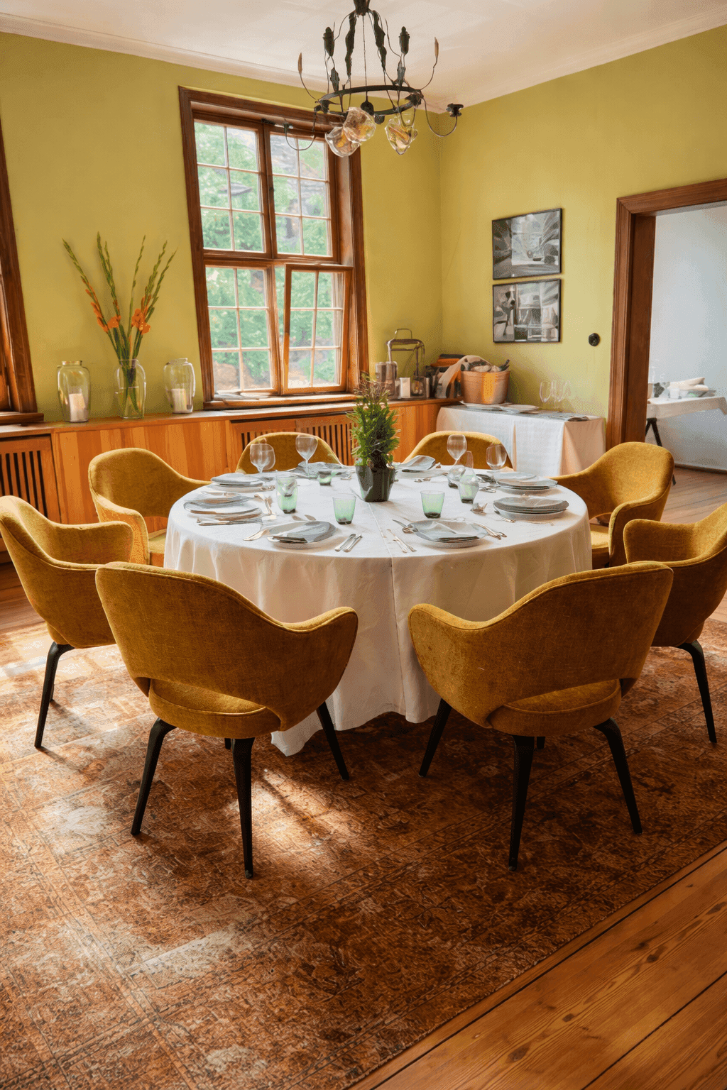 Küchen- und Essbereich eines Privathauses in Potsdam mit großem Wandspiegel, Küchenzeile aus Naturstein und rundem Esstisch mit senfgelben Saarinen-Sesseln auf Orientteppich, Innenarchitektur Susanne Philippson