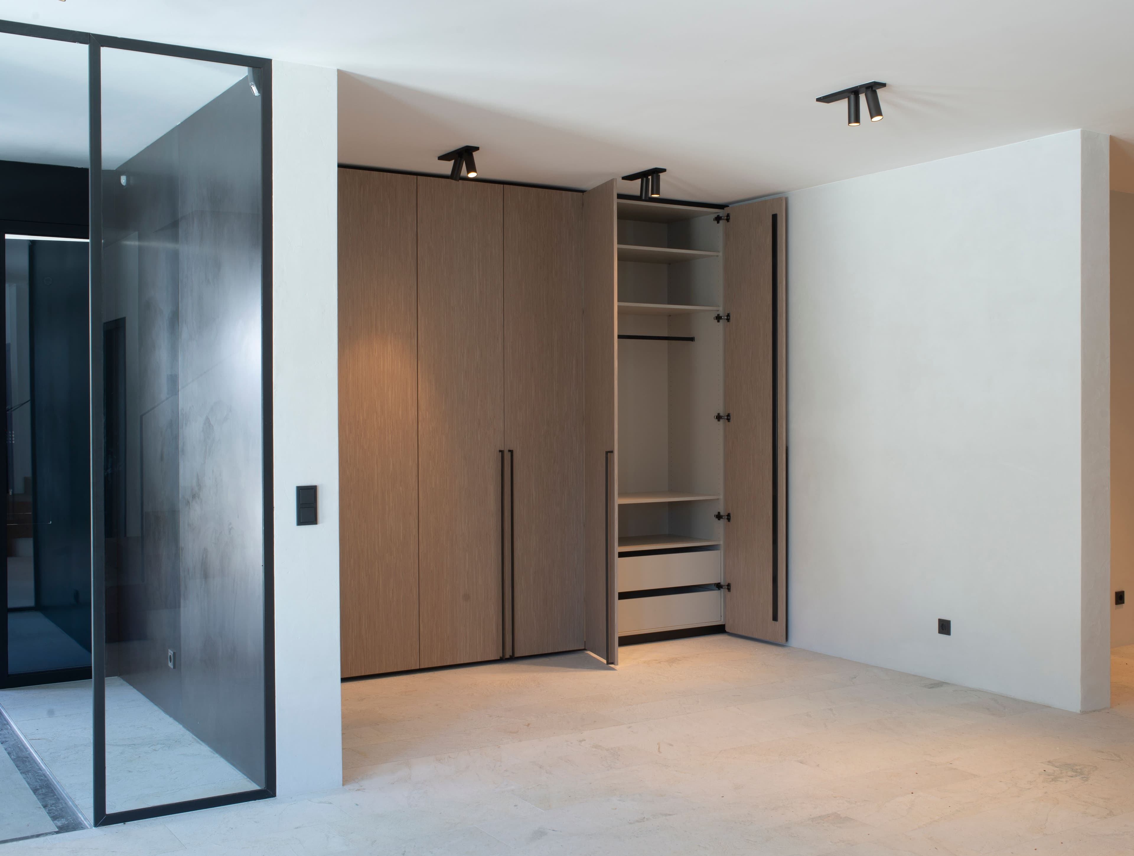 Maßgefertigter Einbauschrank mit Holzfronten und offener Klappe in einem Schlafzimmer eines Privathauses in Tirol, Innenarchitektur Susanne Philippson
