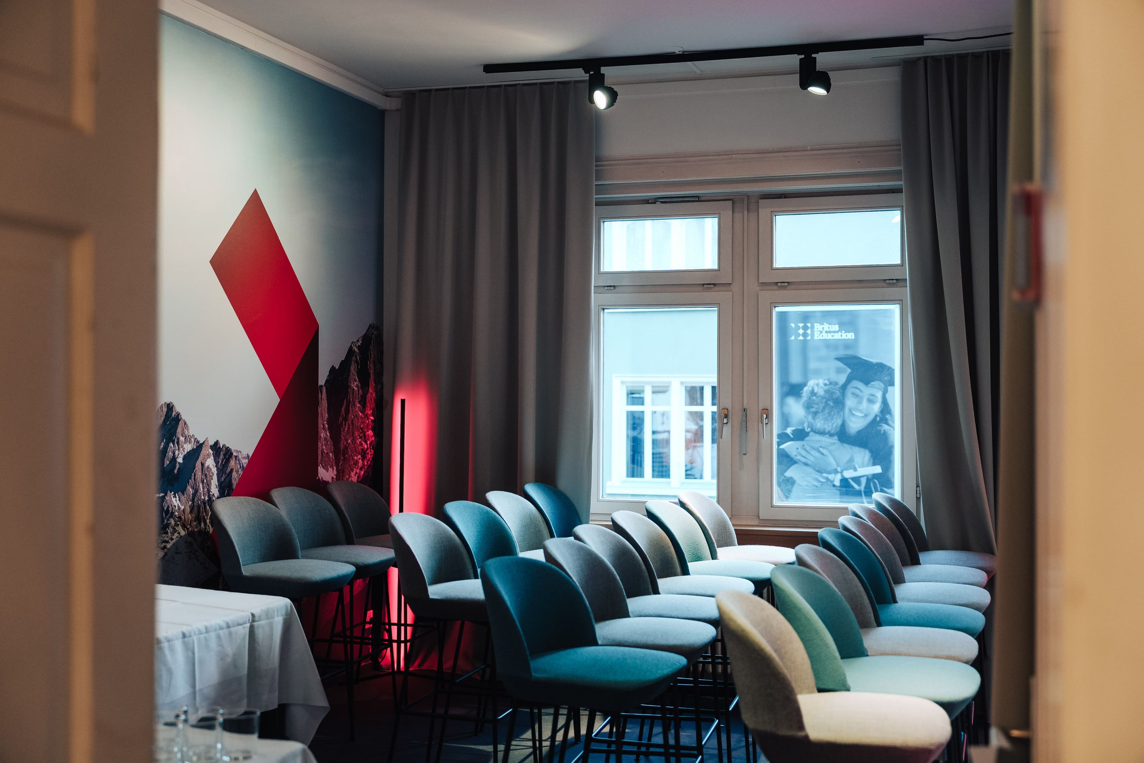 Panelraum und Speaker-Lounge des AI House Davos mit gebrandetem Pixelmuster-Hintergrund, Bestuhlung und Panoramafenster zur Promenade, Innenarchitektur Susanne Philippson