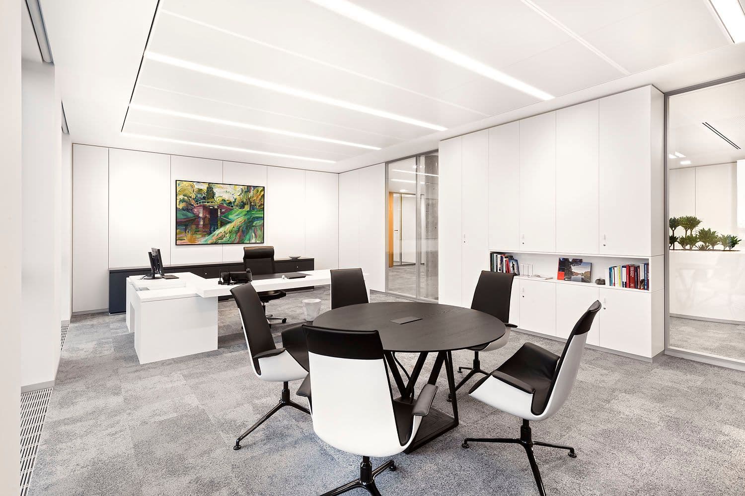 Besprechungsraum im Hauptsitz der Mittelbrandenburgischen Sparkasse Potsdam mit rundem Konferenztisch, schwarz-weißen Drehstühlen, wandmontiertem Display und Eichenholztür mit Lamellenelement, Innenarchitektur Susanne Philippson