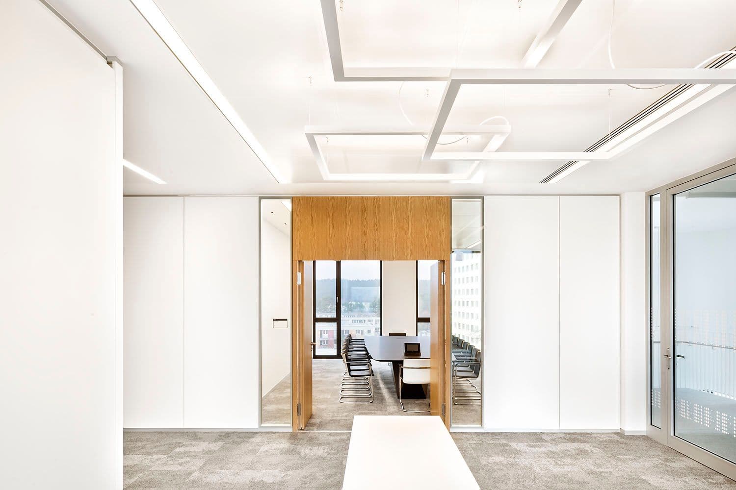 Blick in den Vorstandssitzungssaal im Hauptsitz der Mittelbrandenburgischen Sparkasse Potsdam mit langem Konferenztisch, Eichenholzeinfassung, geometrischem Deckenlichtraster und Panoramaverglasung zur Stadtansicht, Innenarchitektur Susanne Philippson