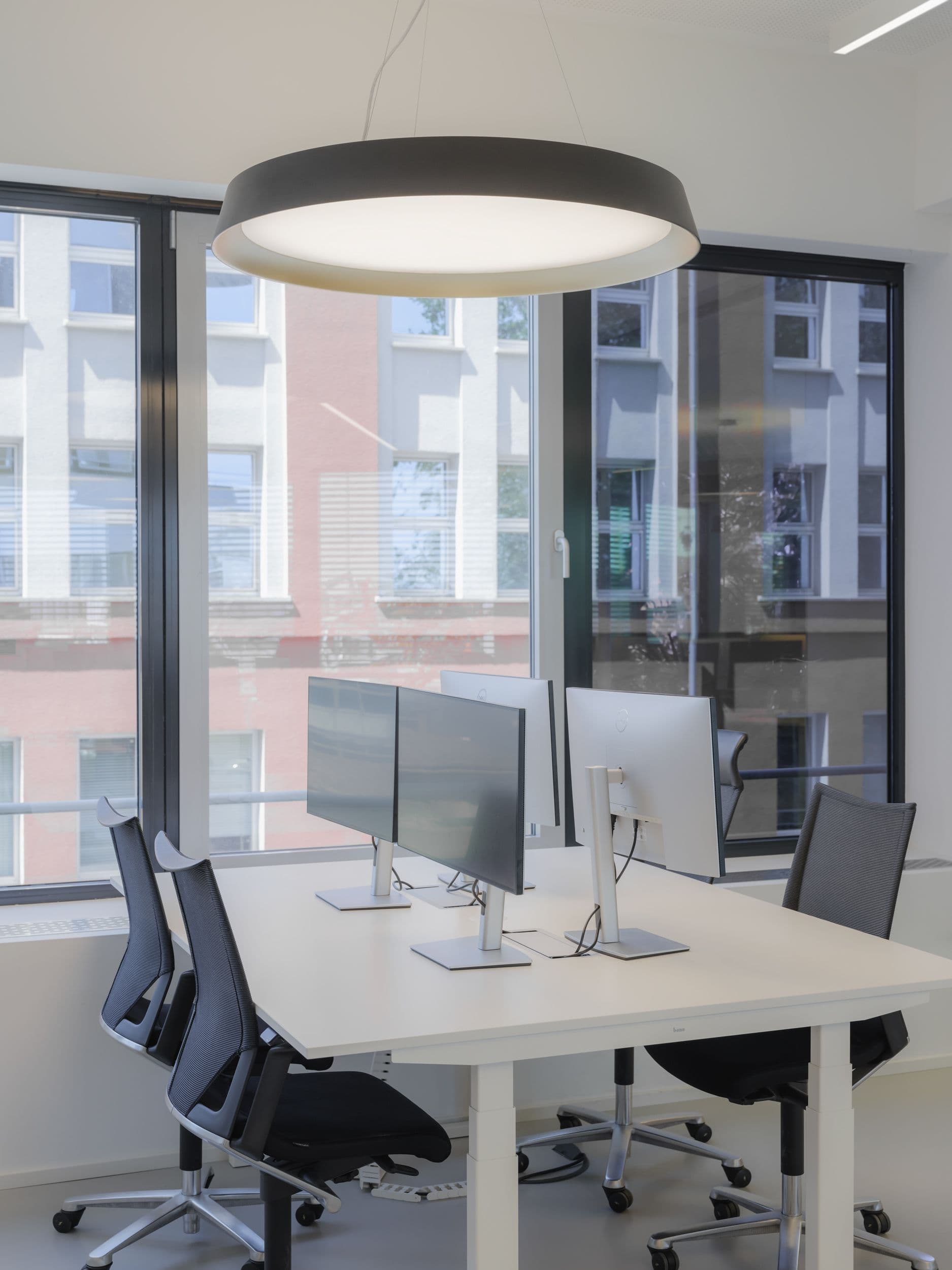 Offener Arbeitsbereich mit Formo-Logo, Wandbegrünung und Glastrennwänden im Projekt Formo Frankfurt