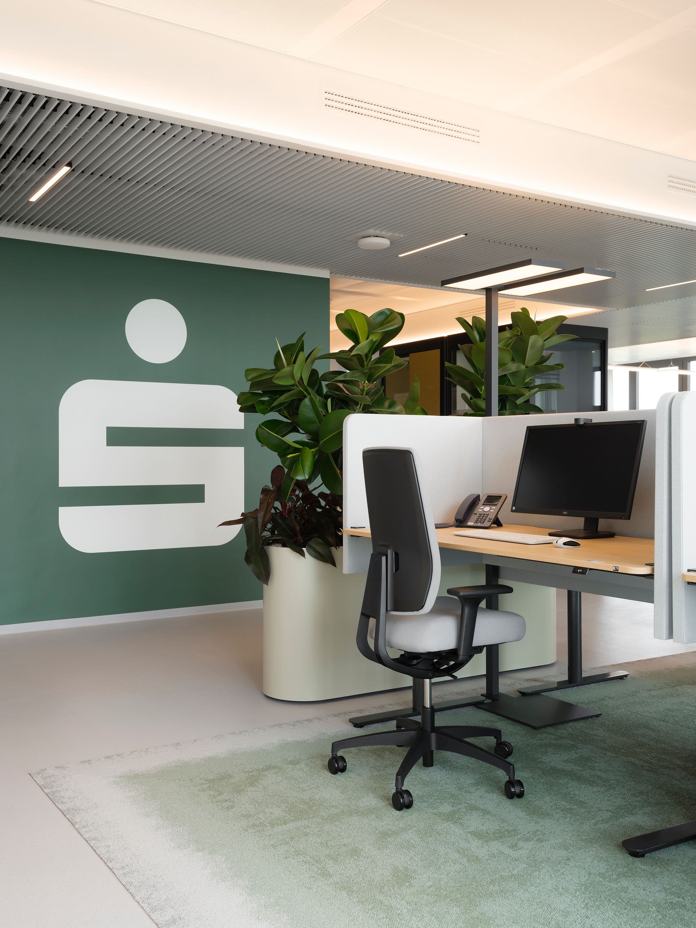 Bürogeschoss der Berliner Sparkasse mit grüner Markenwand, Sparkassen-Logo und begrünten Arbeitsbereichen, Branding Susanne Philippson