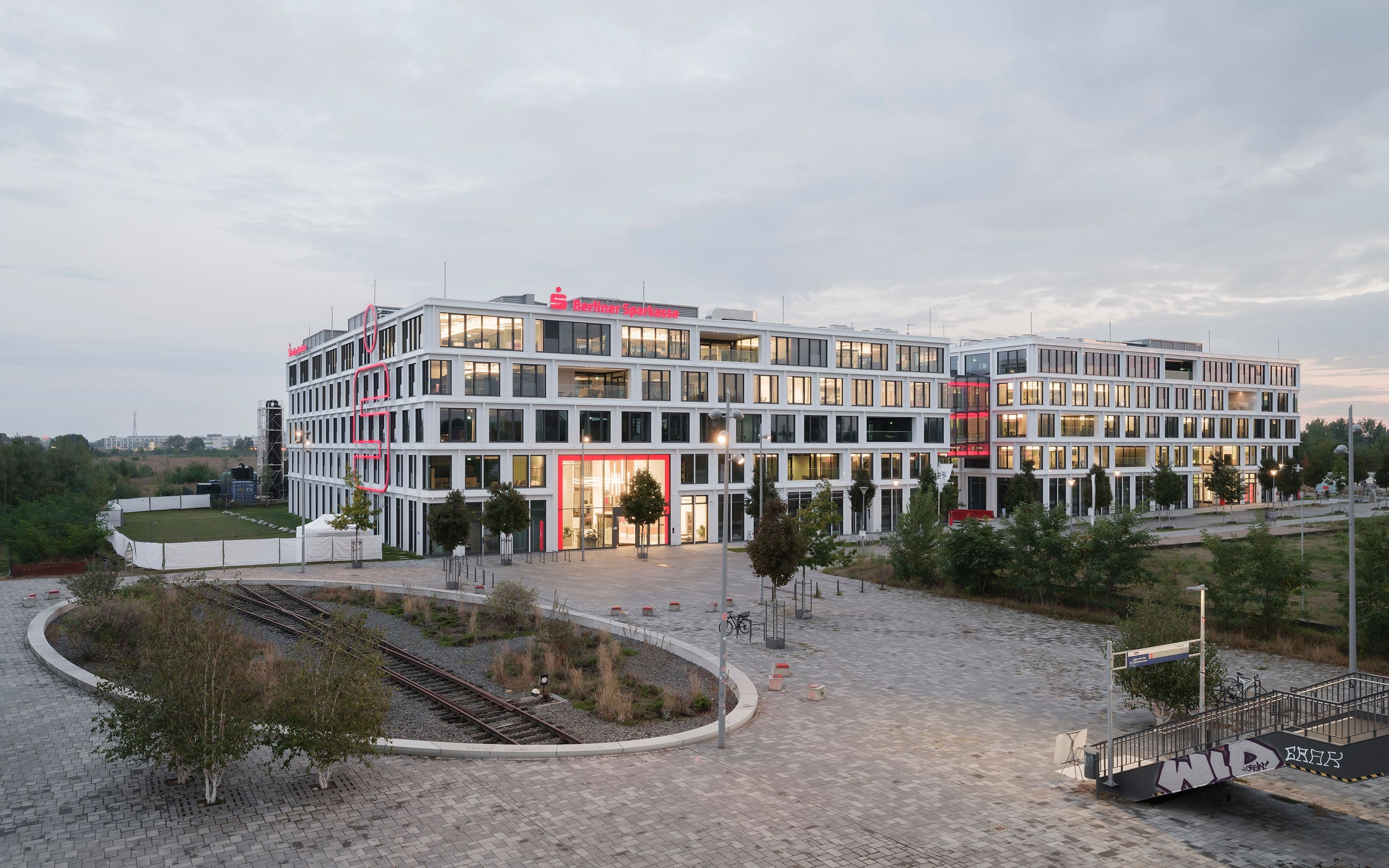 Square-One-Headquarter der Berliner Sparkasse bei Nacht – rot leuchtende Lichtbrücke zwischen den Gebäudeteilen als weithin sichtbares Stadtlandmark, Lichtplanung Susanne Philippson